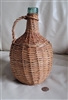 Aqua green wine bottle in wicker basket enclosure