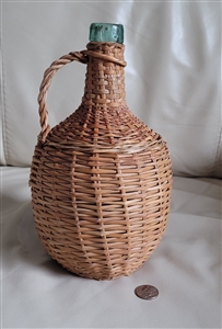 Aqua green wine bottle in wicker basket enclosure