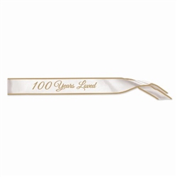 The 100 Years Loved Satin Sash is white with 100 Years Loved displayed in gold lettering. Measures 33 inches long and 4 inches wide. Contains one per package. No returns.