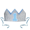 The Glittered Baby's 1st Birthday Crown is a silver glittered crown with light blue lining and a blue "1" on the front. It has two detachable ribbon ties and measures 4 1/2 inches wide and 2 1/2 inches tall. Contains one (1) per pack. No returns.