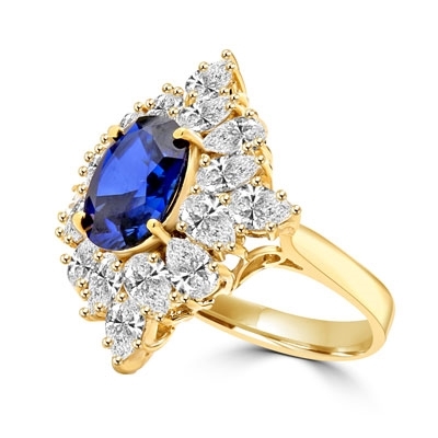 Designer ring with 3.5 Ct. oval Sapphire Essence set in four prongs, and surrounded by pear cut diamond essence stones in floral pattern. 8.5 Cts. T.W. et in 14K Solid Yellow Gold.