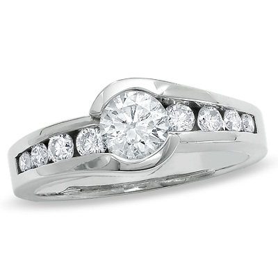 Designer Ring with channel set, 1.0 Cts. Round Brilliant Diamond Essence in center accomapnied by graduating melee on either side, 1.30 Cts. T.W. set in Platinum Plated Sterling Silver.