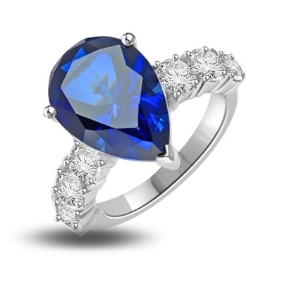 Diamond Essence Designer Ring with 5.50 cts. Pear Cut Sapphire Essence in center and three round stones on each side of center. 7.0 Cts. T.W. set in 14K Solid White Gold.