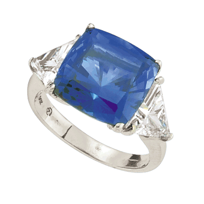 Sapphira - Fantastic Ring with a plush 4 Ct. Cushion Cut Sapphire Essence Masterpiece that highlights by each side of Trilliant accents.6 Cts. t.w. in 14K Solid White Gold, to chase your blues away!
