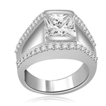 A unique contemporary Ring featuring a channel set 2 Ct. Princess Cut Diamond Essence Masterpiece with a melee of Round Cut accents. Thoroughly impressive 2.75 Cts. T.W, in 14K White Gold..