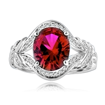 All eyes oval-cut 4.0 cts. Diamond Essence ruby at the center of this 14k Solid White Gold ladies ring, encircled by Diamond Essence melee that culminates in a fancy knotted shank. Spicy! 4.10 cts. t.w.