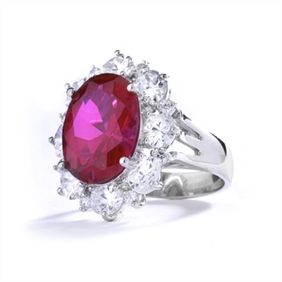 Gorgeous Ring with 8.25 Cts. Oval Cut Ruby Essence in center, surrounded by Oval cut Diamond Essence and Round Brilliant Melee. 10.25 Cts T.W. set in 14K Solid White Gold.