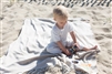 Adorable baby playing on the beach and laying on his personalized Blanket in Sand color with NEON personalization.