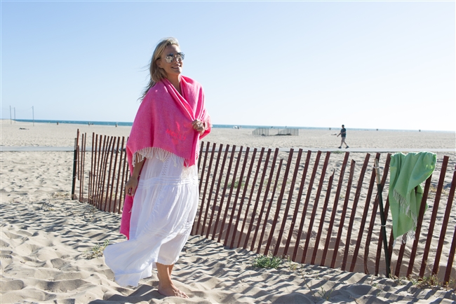 Molly Sims wearing the Neon Pink Blanket wrapped around her shoulders displaying the Neon Pink thread colors and graphics.