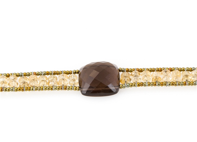 Ziio's Armonia Tennis Bracelet features a large Smokey Quartz Gemstone at the center with Gold Citrine Gemstones on the band. Gold Murano Glass seed Beads outline the band. 925 Sterling Silver Button Closure, adjustable in length.