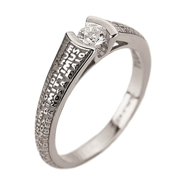 This Solitaire Diamond Ring is embellished with the Lords Prayer in relief around the band. Thanks to the precious gold, the Latin words stand out clearly protecting the diamond. 18k White Gold