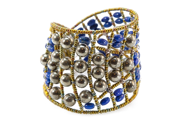 Beauty is in the simplicity of this statement Cuff Bracelet by Ziio. Hand crafted in Italy, features the contrast of Pyrite Beads with Blue Lapis Gemstones. Beaded on Stainless Steel wire with Golden Murano Glass seed beads. Sterling Silver Button closure