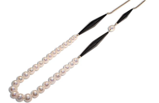 Known for her mix of Ebony with Pearls, Coco gives a new age look to a classic style. Three large accent pieces of Black Ebony add contrast & interest to this White Fresh Water Pearl Necklace. 925 Sterling Silver Gold Plated Chain Li