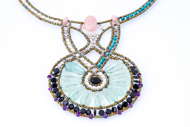 Statement Art-to-Wear Necklace by Ziio. Hand crafted in Italy, the Fluorite Gemstone center Pendant is surrounded by a row of small Black Onyx Beads accented with Amethyst Gemstones. The asymmetrical Neckline features Turquoise & White Water Pearls