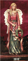 A cast ceramic figure of a tall, thin angel. They have long blonde hair and wear a red robe with gold accents over a long green skirt with gold stars. They hold an evergreen wreath with a red bow in their left hand and a string of bells in their right.