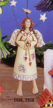 A cast ceramic figure of a stylized, smiling angel. She is hung from a branch and her legs are attached in such a way that they dangle from her body and move as she moves. She wears a long white dress and has small wings and a halo above her head.