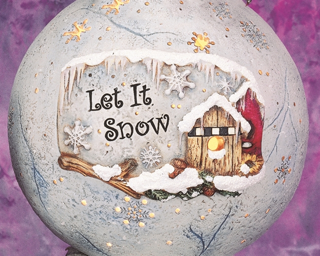 A large cast ceramic sphere with a plaque inserted into its front. The plaque shows birdhouses resting atop a branch, all covered in snow. Icicles hang down from the plaque top and snowflakes fall around the carved words Let It Snow below.