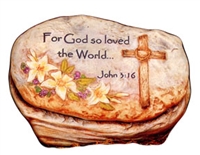 An oval-shaped cast ceramic stone slab placed in a cast ceramic rock base. The slab is flat on either side. The front side shows a wooden cross on the right with lilies and other greenery on the bottom left. The beginning of John 3:16 is carved above.