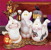 A scene of multiple cast ceramic pieces. Three ghosts sit atop a stone-textured base with a tree and gravestone behind them. The left ghost covers its eyes, the middle its mouth, and the right its ears. The tree behind has a sign that says No Haunting.