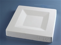A white plaster mold for pressing moist clay into shapes on a blue background. It is large and square in shape, with a smaller square carved into the center surrounded by angled edges.