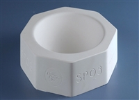 A white plaster mold for pressing moist clay into shapes on a blue background. It is octagonal in shape. A large inverted circular dome is carved into the center.