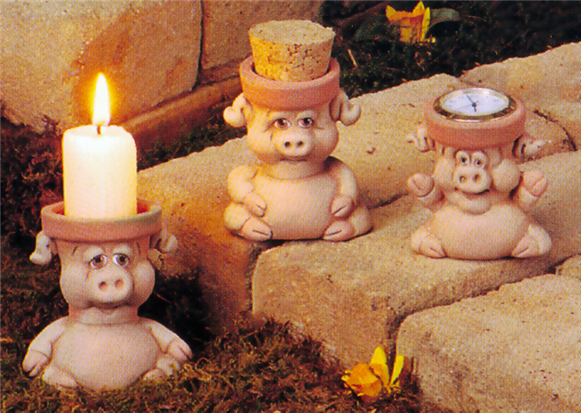 Three small, separate cast ceramic pigs, each with a head as a functional pot. The pigs are cartoonishly styled. The left sits, arms at its sides. The middle sits with arms wrapped around its belly. The right sits with its arms raised gleefully.