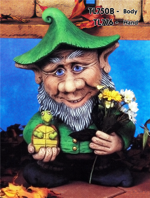 A cast ceramic figure made of multiple pieces assembled into a cartoonish gnome. He has a large nose and ears, wears  a cap, and has long facial hair. He stands with his right hand extended, holding a small turtle. He wears a small smile.