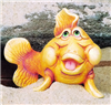 A cast ceramic figure of a cartoonishly styled fish with a humorous expression. It gazes upward, mouth held open with visible tongue. It is posed with its tail slightly to one side and its pectoral fins against the ground in front of it, raising it.