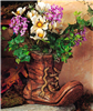 A cast ceramic planter shaped like a worn boot. The toe of the boot is bent upwards and its laces are undone and frayed at the ends. It is wrinkled and painted to resemble old leather. It is filled with real flowers and greenery.