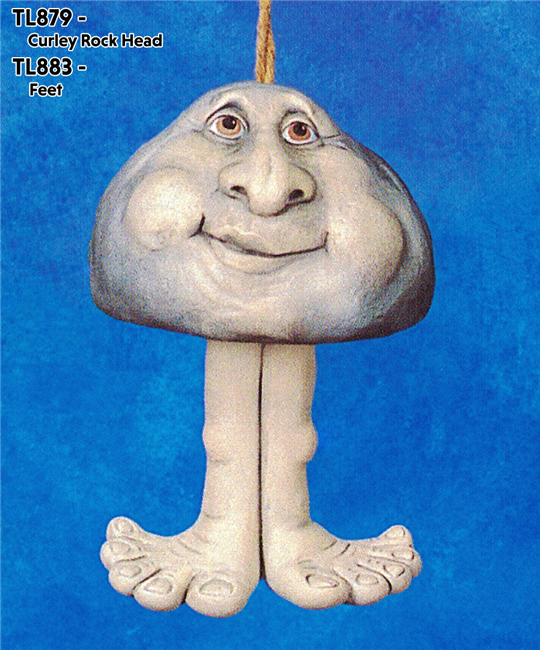 A cast ceramic figure of a rock with a cartoonish human face. It has a large nose and lopsided smile. It has a flat base and has been placed on a separate pair of cast ceramic legs and feet. The legs are long and knobbly and the feet wide.