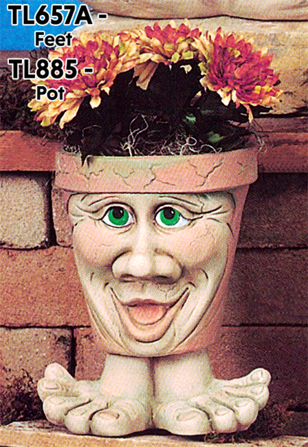 A cast ceramic pot with a cartoonish human face. The face has an open mouth smile, very large nose, and large eyes. The pot is textured with small lines like aged cracks and is placed atop a pair of wide cartoonish cast ceramic feet.