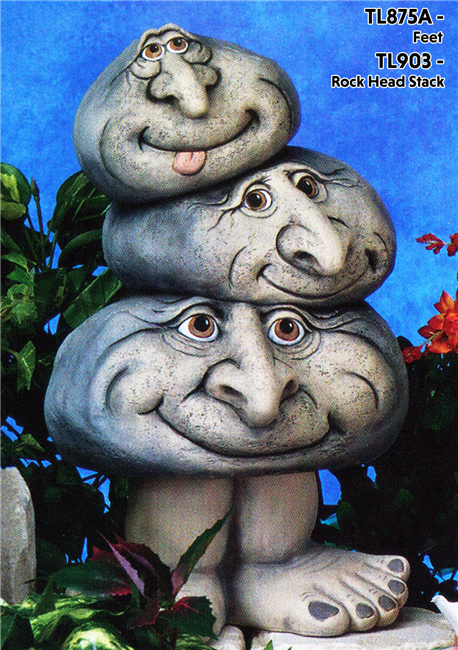 A cast ceramic statue of three stacked rocks atop a pair of legs, each with a cartoonish human face with large nose. The largest bottom rock looks forward with a smile. The middle rock looks to the side with a grin. The top rock looks forward, tongue out.