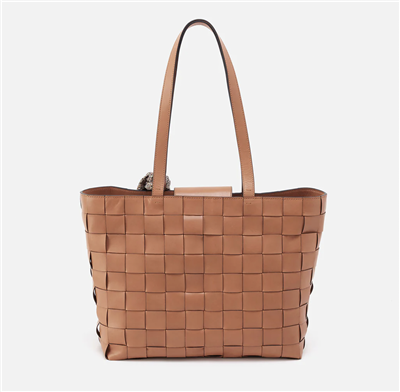Women's woven leather tote bag in white color with a printed scarf tied around the strap.