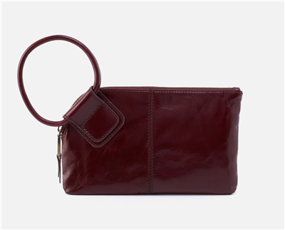 Women's leather clutch handbag in merlot with a circular handle and a top zip.