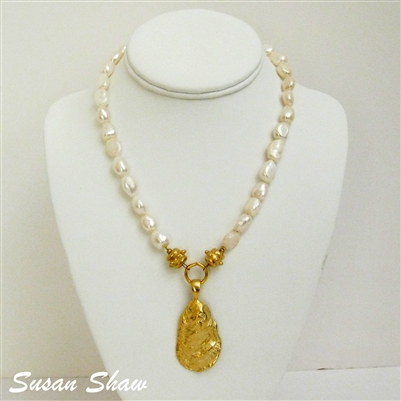 Gold plated Oyster Shell hanging from a freshwater pearl necklace
