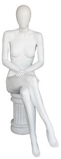 Female egghead mannequin in seated pose. Her legs are crossed with her hands on her lap.