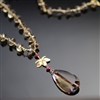 Aurora's Charm Necklace photo. Gorgeous smoked quartz stones make up most of the necklace. They are combine by 18k yellow gold hooks and have a gold lotus flower that attaches the top part to the big, drop shaped smoked quartz stone and little red rubies.