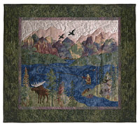 Quilt block of a man fishing in a river in the mountains, watched by an elk, with geese flying overhead.