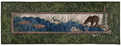 Quilt block of a brown bear fishing in a river.