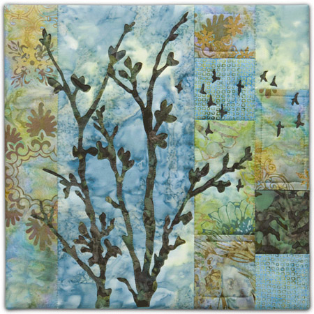 Quilt block with stylized tree and flock of birds flying in blue, yellow, and green floral patterns