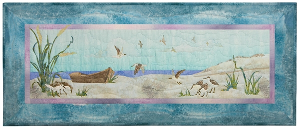 Quilt block of an empty boat on the beach, with sandpipers circling and looking for food.