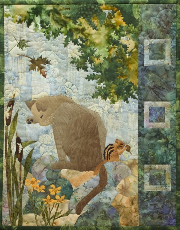 Quilt block of a brown cat rubbing his face, while leaves fall overhead and a chipmunk eats an acorn.