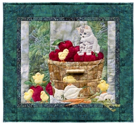 Quilt block showing a kitten watching over some new chicks, while perched on a bushel of apples.