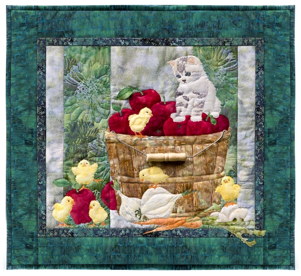 Quilt block showing a kitten watching over some new chicks, while perched on a bushel of apples.