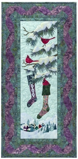 Quilt block of cardinals hanging stockings in a tree.