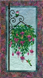 Quilt block of hummingbirds drinking nectar from a hanging plant.