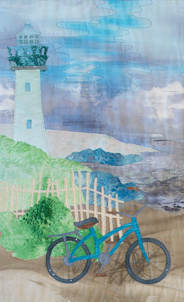 Quilt block of a bicycle leaning on a white picket fence, with a path leading up to the lighthouse that overlooks the ocean.