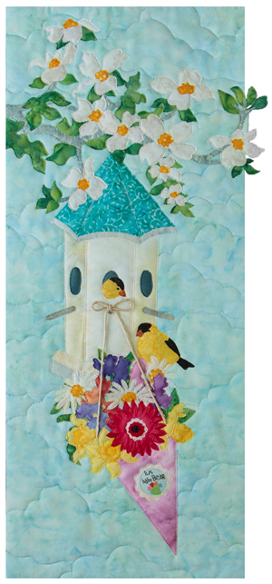 A bird house hanging on a flowering tree branch, with a bouquet of beautiful, colorful flowers hanging off the front. Two small yellow birds are sitting on the flowers and in the bird house.