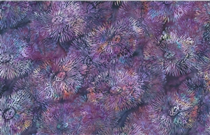 Batik fabric with a sea anenome print in purple with pink and orange accents