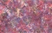 Batik fabric with an abstract fish scale print in dark pink and maroon tones